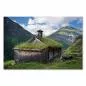 Preview: Traditionelles norwegisches Bauernhaus mit Grasdach, Berge im Hintergrund.