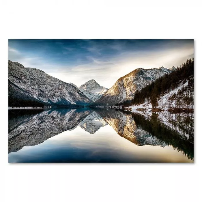 Ein kristallklarer See in den Alpen spiegelt die schneebedeckte Winterlandschaft – ein Bild von Ruhe und Schönheit.