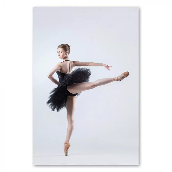 Ballerina in schwarzem Tutu, steht auf einem Bein - Kraft & Entschlossenheit.