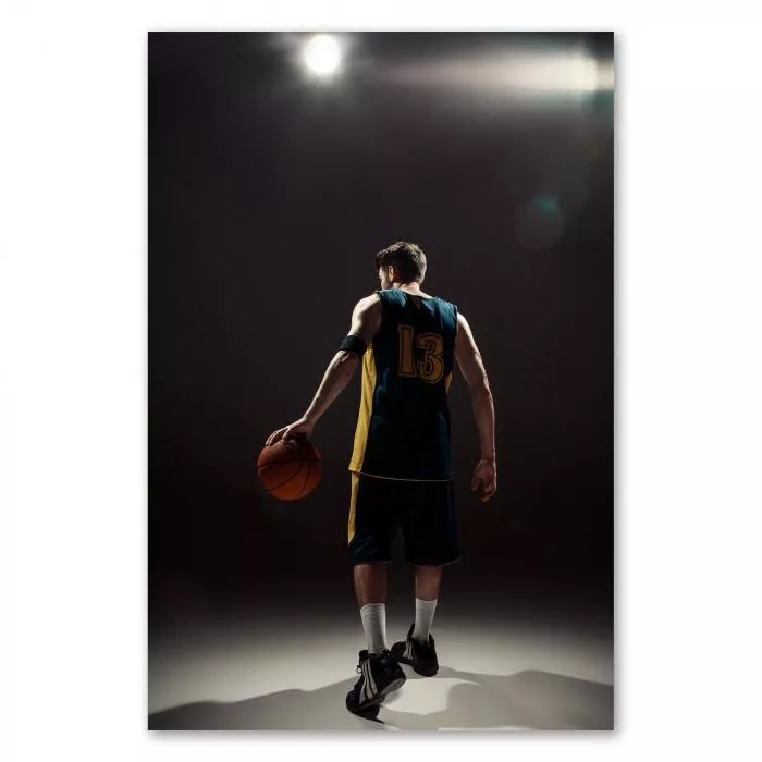 Action und Dynamik: Ein Basketballspieler im Spotlight - dieses Bild fängt die Faszination des Sports ein.