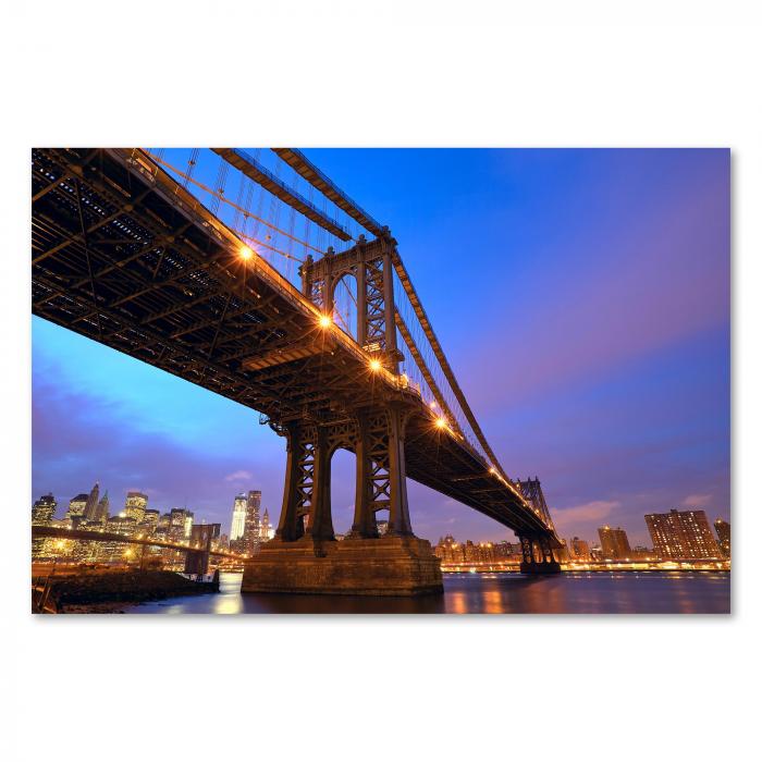 Brooklyn Bridge erstrahlt im Licht der untergehenden Sonne, Skyline von Manhattan im Hintergrund.