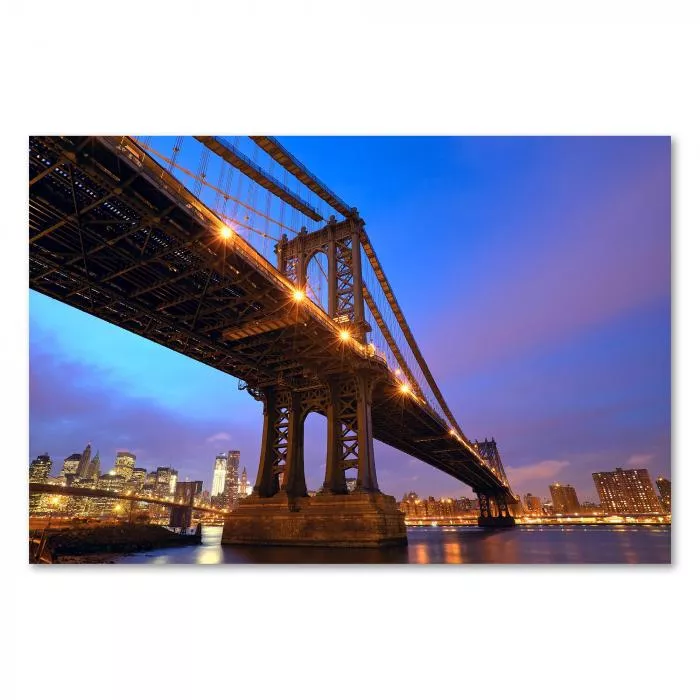 Brooklyn Bridge erstrahlt im Licht der untergehenden Sonne, Skyline von Manhattan im Hintergrund.