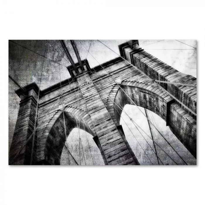 Abstrakte Schwarzweißfotografie der Brooklyn Bridge mit Fokus auf die imposanten Steinbögen und Stahlseile.