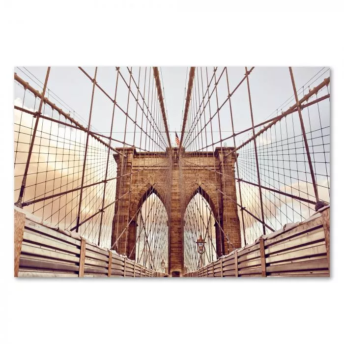 Blick entlang der Brooklyn Bridge mit amerikanischer Flagge im Hintergrund.