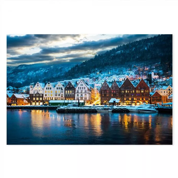 Bryggen in Bergen bei Nacht: Holzhäuser, Schnee, Berge, Hafenbecken.