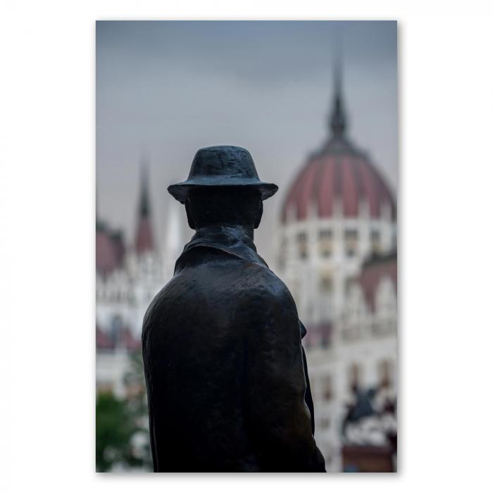 Statue eines Mannes mit Hut blickt auf Parlamentsgebäude in Budapest.