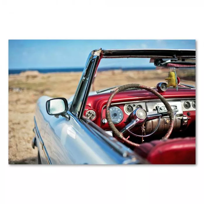 Ein weißes Cabrio am Strand versprüht Urlaubsfeeling mit Blick aufs Meer und offenem Verdeck.