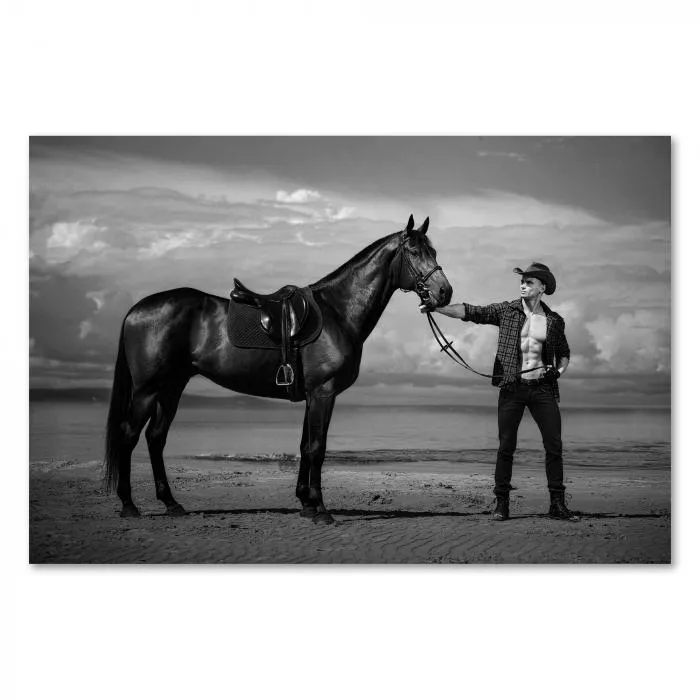 Ein Cowboy mit seinem Pferd am Strand - ein Schwarz-Weiß-Motiv voller Freiheit und Abenteuer.