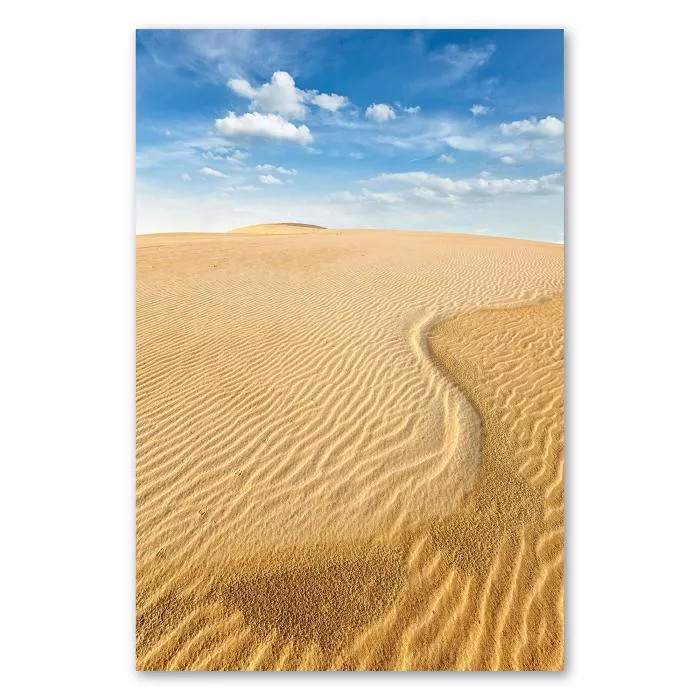 Endlose Sanddünen unter blauem Himmel, weiße Wolken, Sonne taucht Landschaft in warmes Licht.