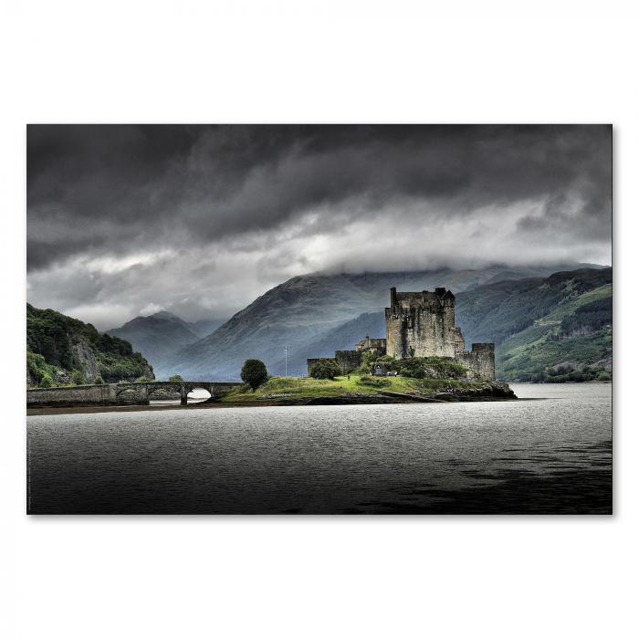 Eilean Donan Castle auf einer Insel, verbunden durch eine Steinbrücke, dramatisch unter dem Himmel.