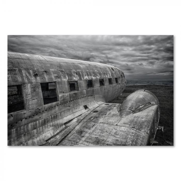 Schwarz-Weiß-Foto eines verlassenen Flugzeugwracks in einer öden Landschaft.