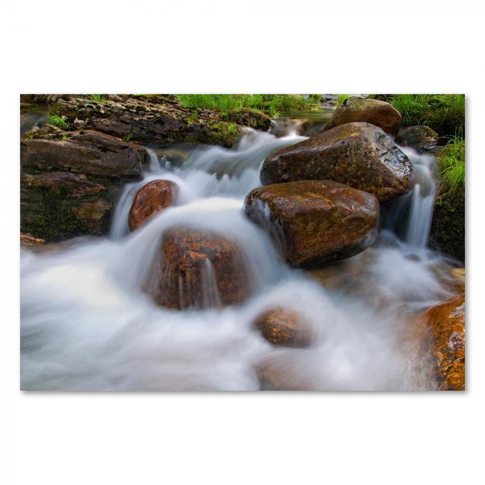 Ein wildromantischer Fluss mit Steinen, eingefangen mit Langzeitbelichtung - ein traumhaftes Motiv.