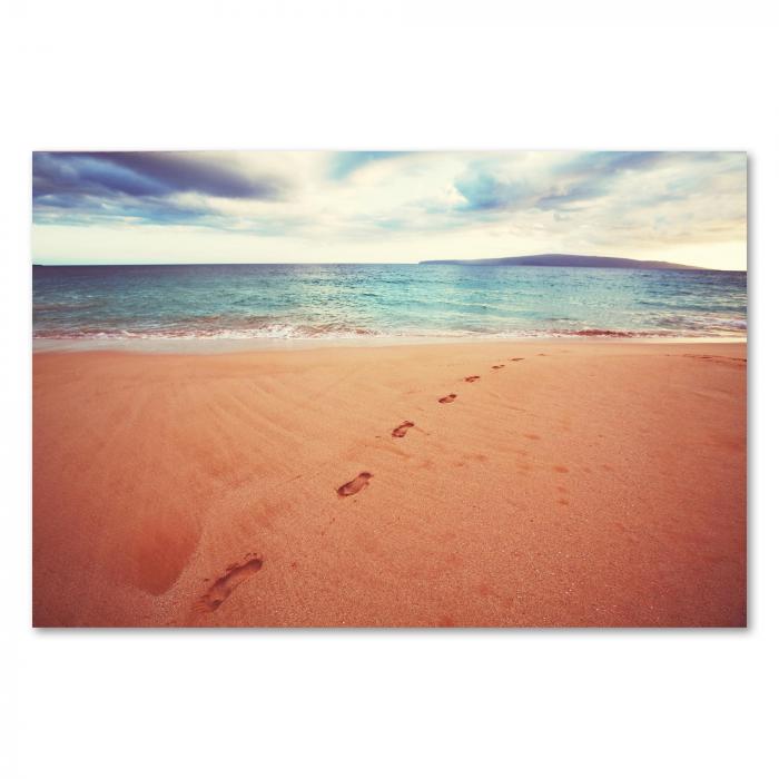 Weiße Sandstrand mit Fußspuren, die ins Meer führen – ein Bild von Entspannung und Urlaubsfeeling.