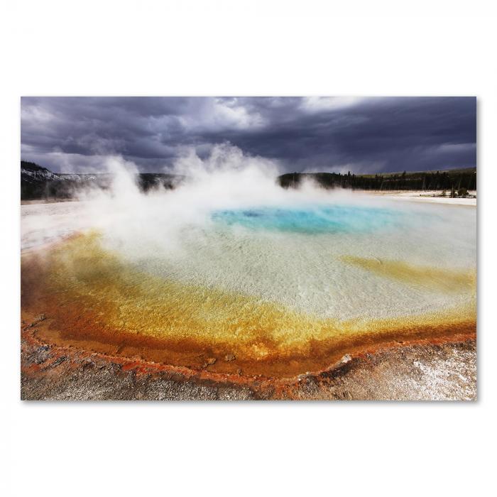 Ein dampfender Geysir mit türkisfarbenem Wasser und bu nten Ablagerungen im Yellowstone Nationalpark.