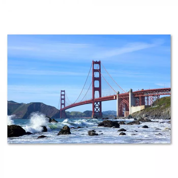 Golden Gate Bridge in San Francisco, blauer Himmel und tosende Wellen im Hintergrund.