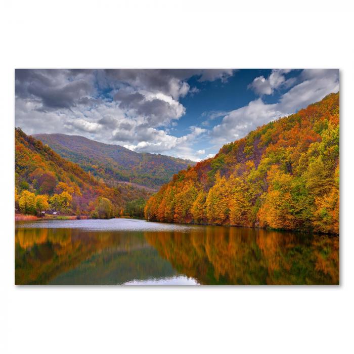 Ein See im Herbst: Bunte Bäume spiegeln sich im Wasser - ein farbenfrohes Motiv.