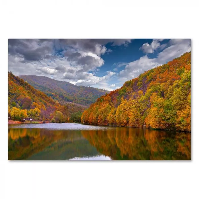 Ein See im Herbst: Bunte Bäume spiegeln sich im Wasser - ein farbenfrohes Motiv.