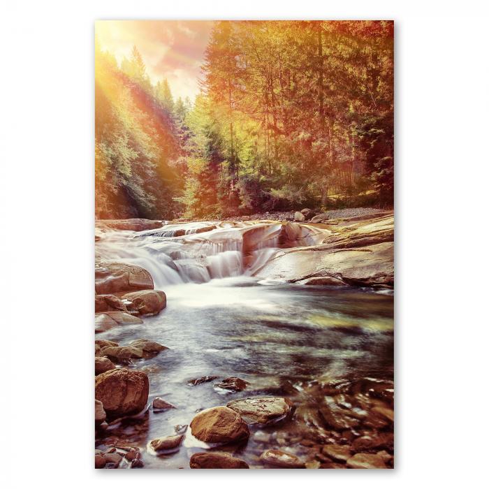 Ein idyllischer Wasserfall im Herbstwald: Bunte Blätter und Sonnenstrahlen tauchen die Szene in warmes Licht.