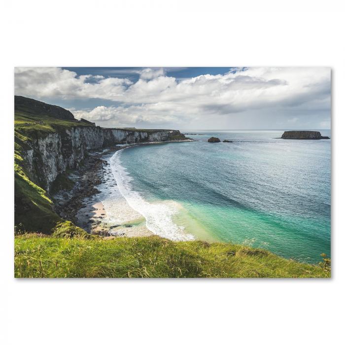 Die raue Schönheit Irlands: Hohe Steilklippen fallen an der Küste ins türkisblaue Meer ab. Ein kleiner Sandstrand lädt zum Verweilen und Genießen der atemberaubenden Landschaft ein.