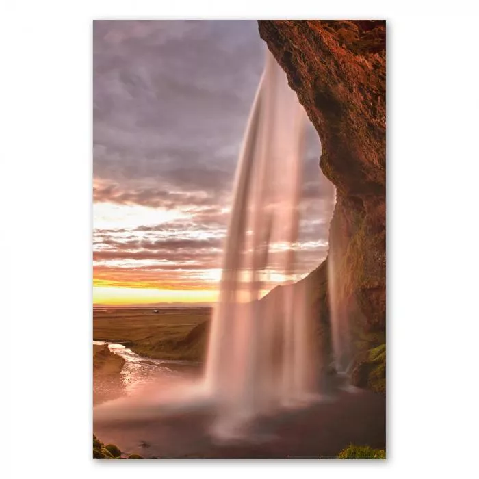 Mächtiger Wasserfall in Island erstrahlt im warmen Licht der untergehenden Sonne.