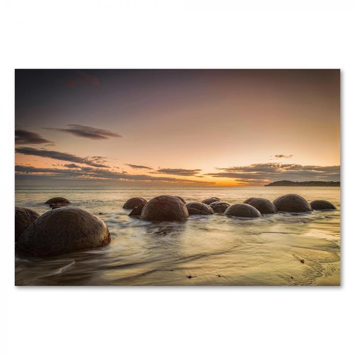 Moeraki Boulders am Strand (Neuseeland), Sonnenaufgang, warmes Licht, mystisch.