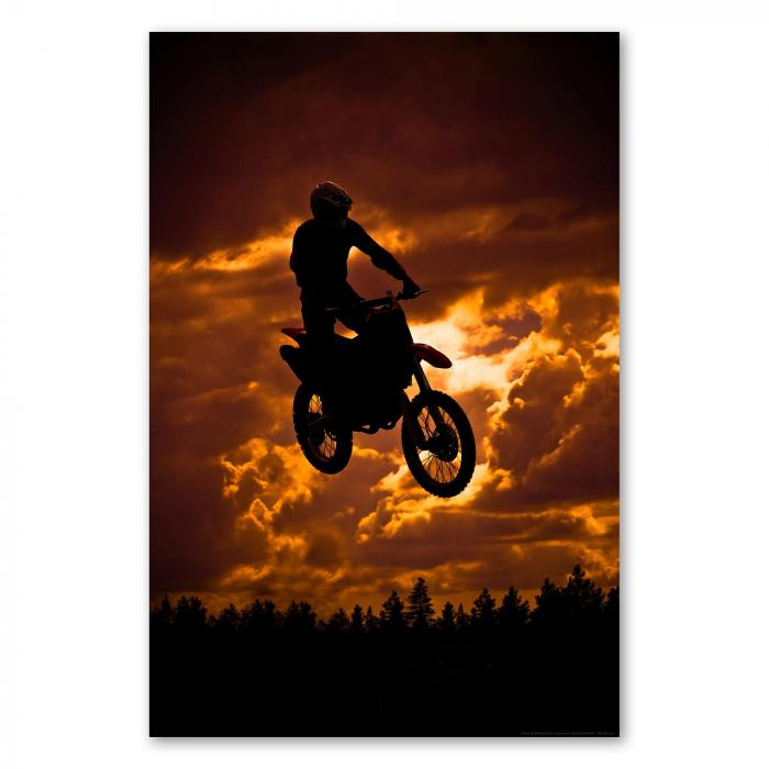 Mit Vollgas in den Sonnenuntergang: Ein Motocross Fahrer springt mit seiner Maschine und liefert ein atemberaubendes Bild.