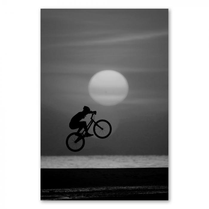 Ein Mountainbiker springt am Strand vor der untergehenden Sonne - ein dynamisches Motiv voller Freiheit.