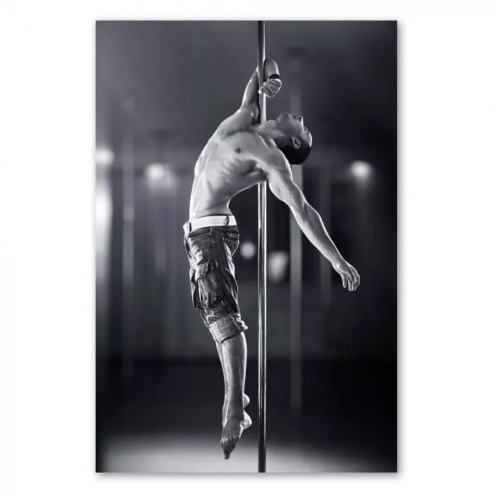 Muskulöser Mann beim Pole Dance zeigt beeindruckende Körperbeherrschung, Schwarz-Weiß betont die Eleganz.