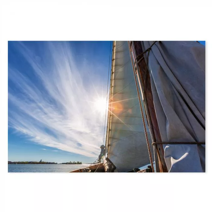 Segelboot, Segel, Sonne, Strahlenkranz, blauer Himmel, weiße Wolken.