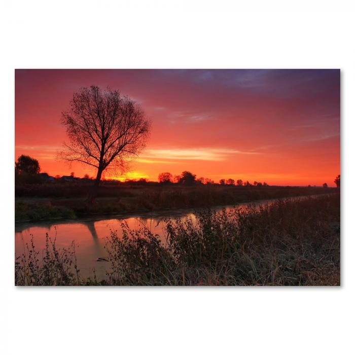 Ein Leuchtturm an der felsigen Küste im warmen Licht des Sonnenuntergangs - ein maritimes Motiv voller Ruhe.