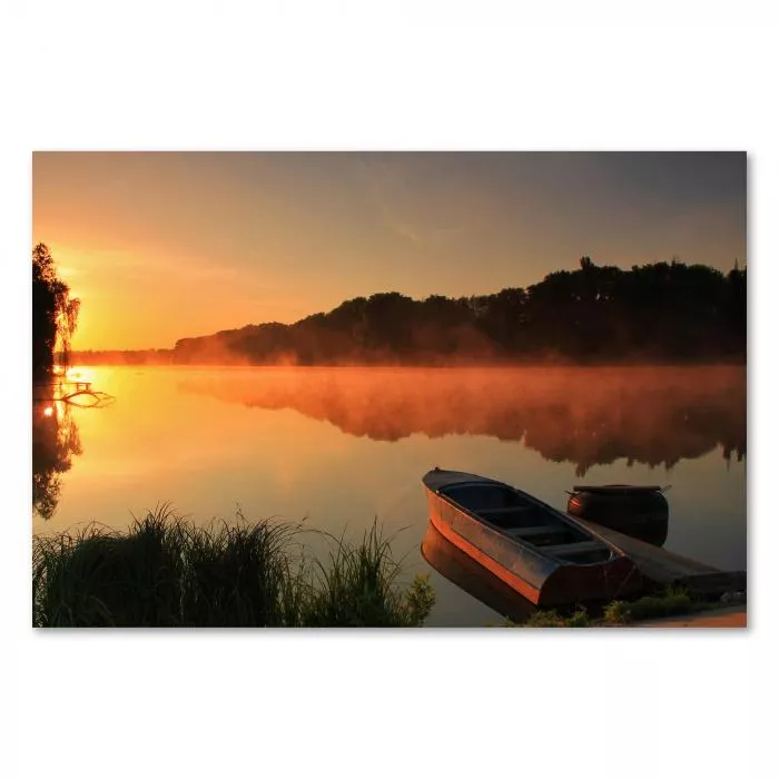 Malerischer Sonnenaufgang über einem See mit Boot, das die Ruhe des Moments einfängt.