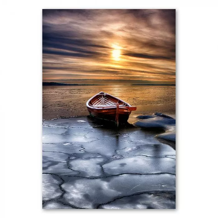 Kleines Holzboot auf gefrorenem See, Sonne untergeht und Himmel erstrahlt in warmen Farben.