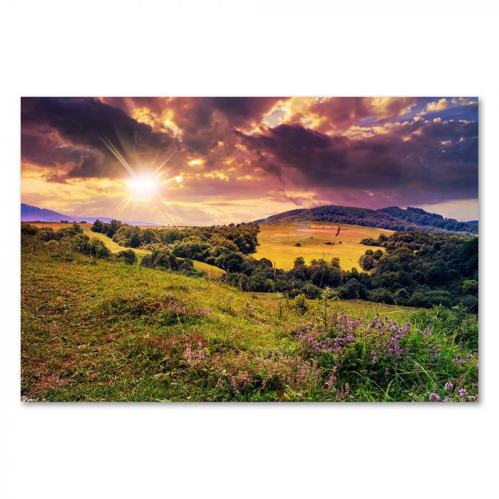 Grüne Hügel & Wälder im Abendlicht, untergehende Sonne, warme Farben.