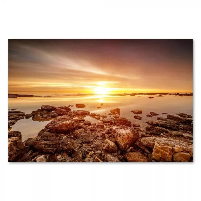 Die Sonne versinkt im Meer und taucht den Himmel in warme Goldtöne - ein atemberaubendes Naturschauspiel.