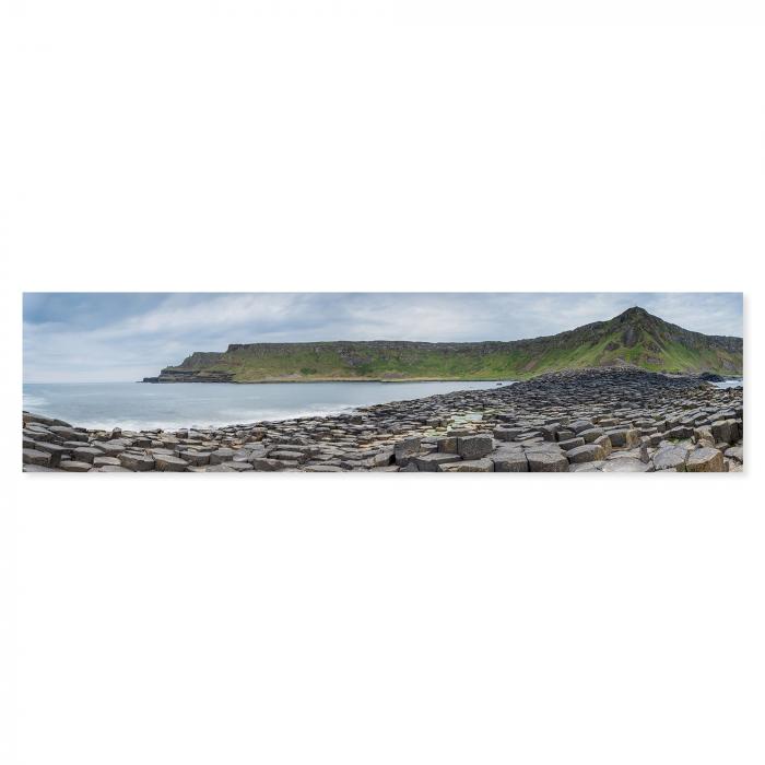 Steinküste Giant's Causeway, Nordirland, einzigartige Formationen, grüne Insel im Hintergrund.