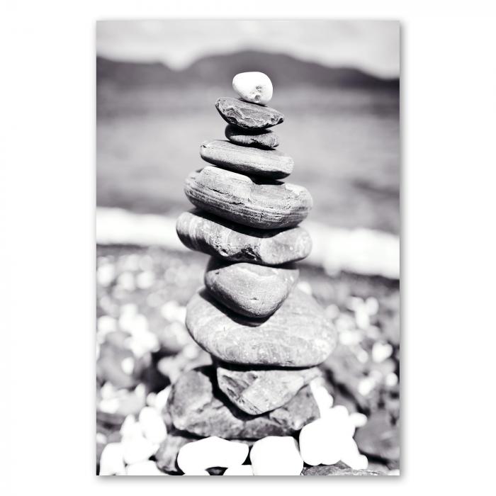 Ein Steinturm am Strand, eingefangen in einer zeitlosen Schwarz-Weiß-Fotografie – ein Symbol für Balance und Harmonie.