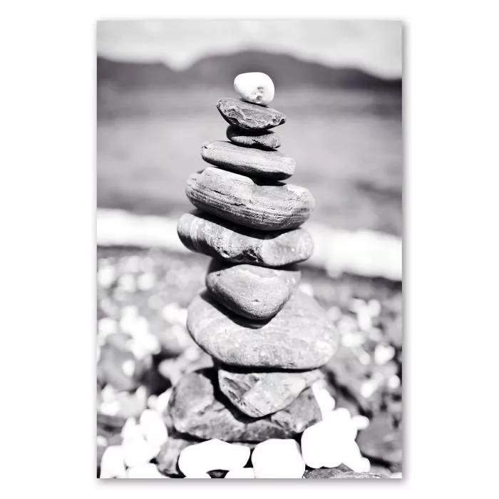 Ein Steinturm am Strand, eingefangen in einer zeitlosen Schwarz-Weiß-Fotografie – ein Symbol für Balance und Harmonie.