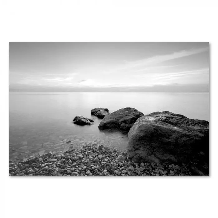 Langzeitbelichtung zeigt die Stille des Meeres an einem steinigen Strand.