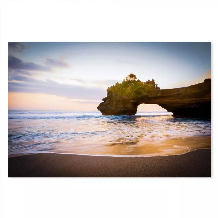 Ein Tempel auf einer kleinen Insel im Meer, von der untergehenden Sonne in warme Farben getaucht - ein exotisches Motiv.