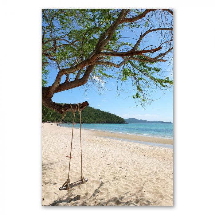 Ein idyllischer Strand mit türkisblauem Meer und einer Schaukel unter einem Baum - ein Traum für alle Urlaubsliebhaber.