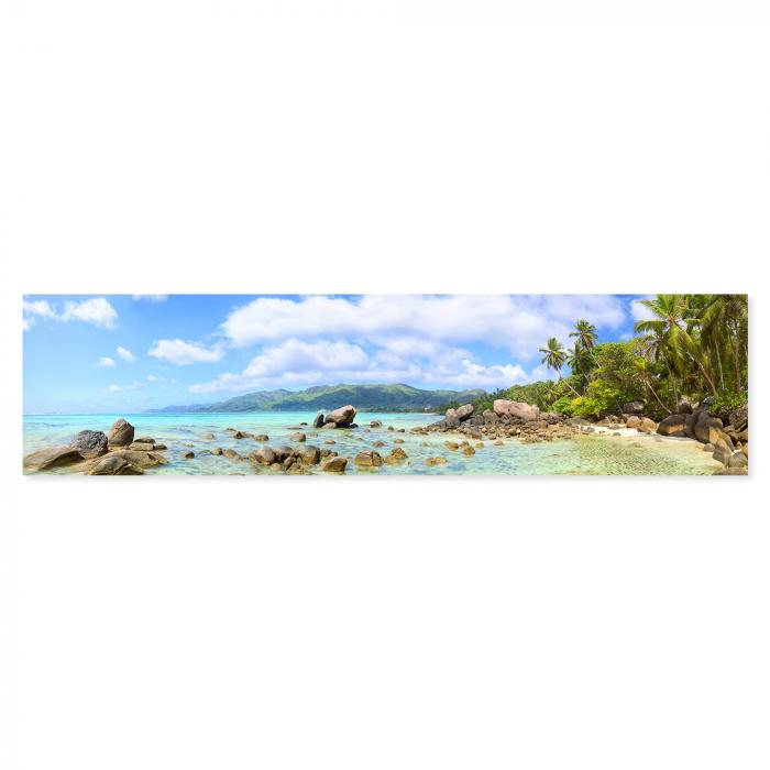 Tropischer Strand auf den Seychellen: Türkisblaues Wasser, Felsen, Palmen.