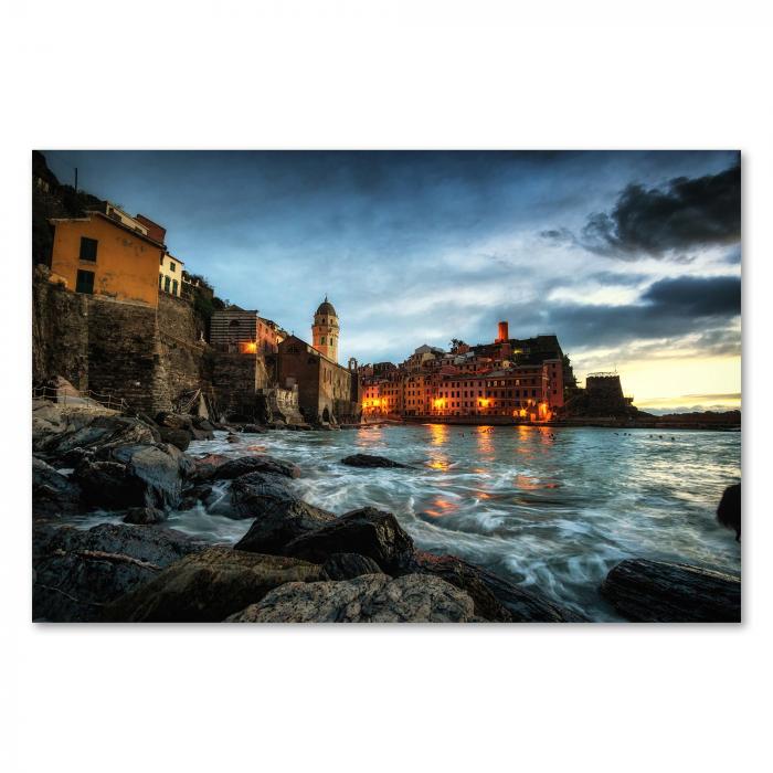 Vernazza (Cinque Terre, Italien) bei Nacht - beleuchtete Häuser spiegeln sich im Wasser.