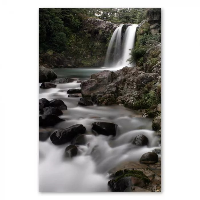 Idyllischer Wasserfall ergießt sich in smaragdgrünen See, umgeben von dichtem Wald, bietet Ruhe und Schönheit.