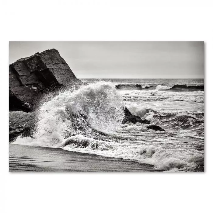 Kraftvolle Welle bricht an Felsen, Gischtfontäne, Schwarz-Weiß-Fotografie.