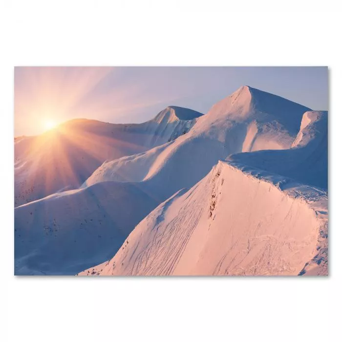 Schneebedeckte Berggipfel im warmen Licht der untergehenden Sonne – ein atemberaubendes Winterpanorama.