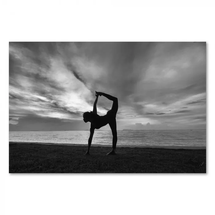 Eine Frau in einer anspruchsvollen Yogapose am Strand – ein kraftvolles Schwarz-Weiß-Motiv voller Anmut.