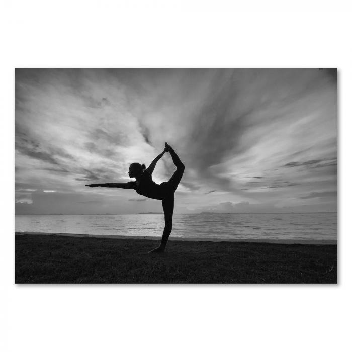 Eine Frau in einer eleganten Yogapose am Strand - ein harmonisches Schwarz-Weiß-Motiv voller Balance.