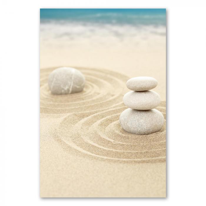 Drei Steine auf einem Sandkreis - ein minimalistisches Bild, das Ruhe und Balance symbolisiert.