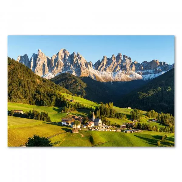 Alpendorf mit Kirchturm, grüne Hügel & Berge, blauer Himmel & Wolken.