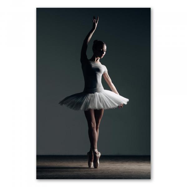 Ballerina in Tutu zeigt elegante Pose auf Spitze, Licht- und Schatten-Spiel verleiht besondere Atmosphäre.